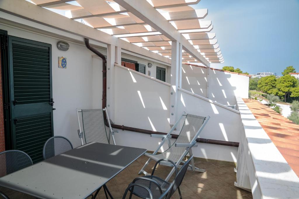 a patio with a table and chairs on a balcony at Residence Chiesiola in Vieste