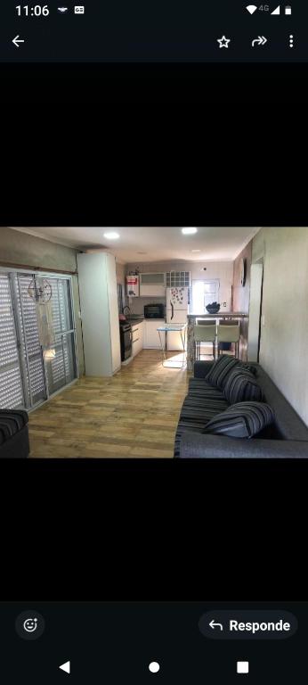 a room with a bed and a kitchen with a table at Alojamiento el cairo in San José