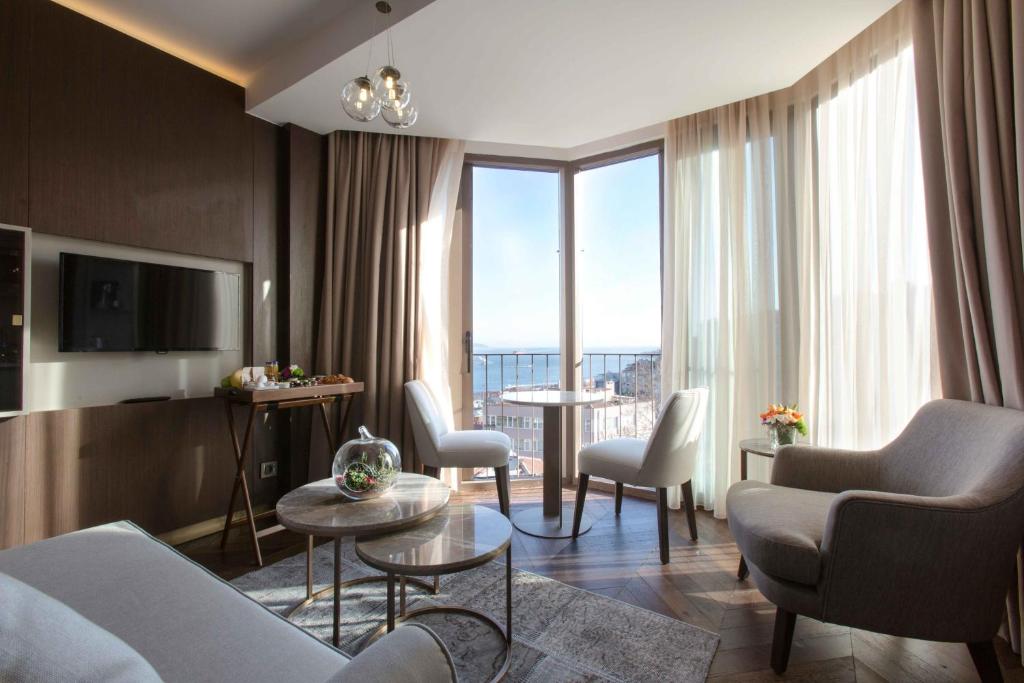 a living room with a couch and chairs and a large window at Noble22 Suites-Special Category in Istanbul