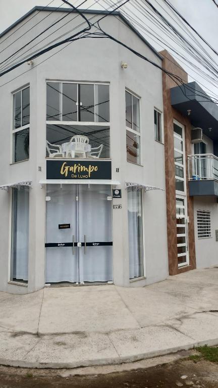 a white building with a sign on the front of it at Apartamento com Vista Panorâmica in São Gabriel