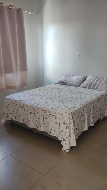 a bed with a blanket on it in a room at Apartamento com Vista Panorâmica in São Gabriel