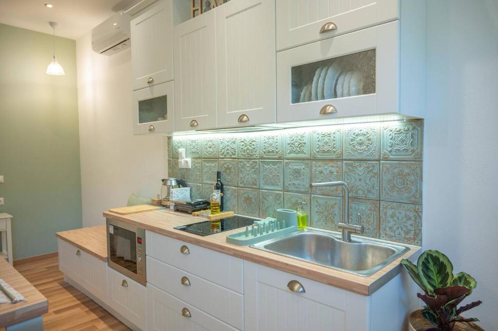 a kitchen with a sink and a counter at Cloe Corfu Town Apartment in Agios Rokkos