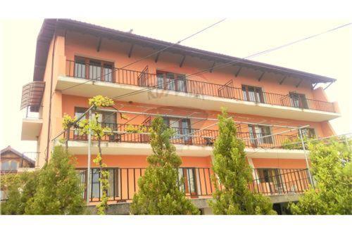 an orange building with trees in front of it at Prostor Guest House in Byala
