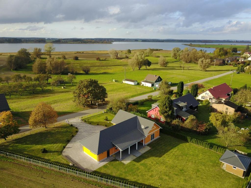 an aerial view of a house in a field with a lake at Fietes Achternutkiek in Mellenthin