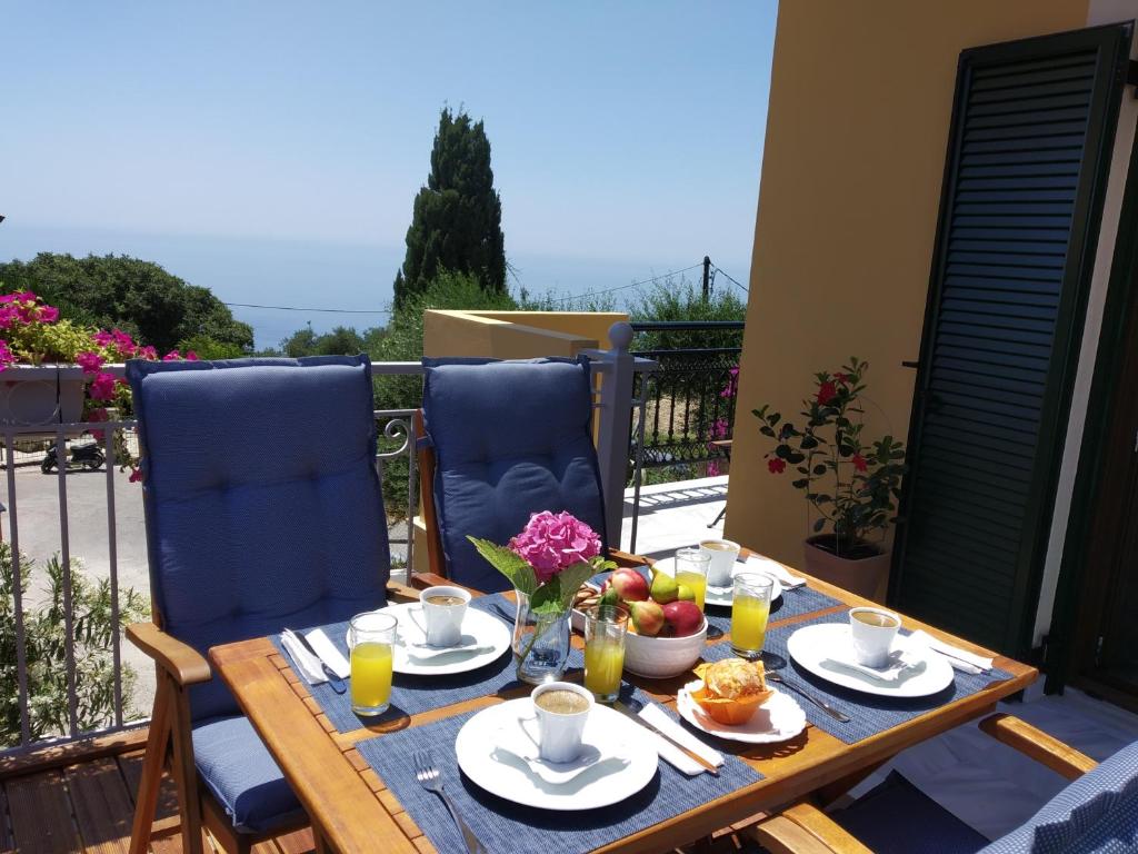 a wooden table with plates of food on a balcony at Kontis Apt 1 in Pelekas