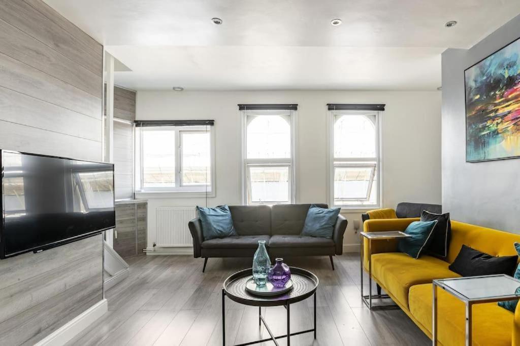 a living room with a couch and a flat screen tv at Modern One Bedroom Duplex Apartment - Central Oxford in Oxford