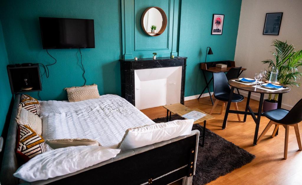 a room with a bed and a table and a mirror at T1 centre-ville refait à neuf in Brest