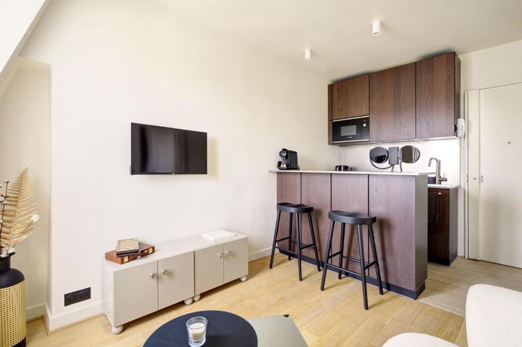 une cuisine avec un comptoir et des tabourets dans une pièce dans l'établissement La vie du marais, à Paris