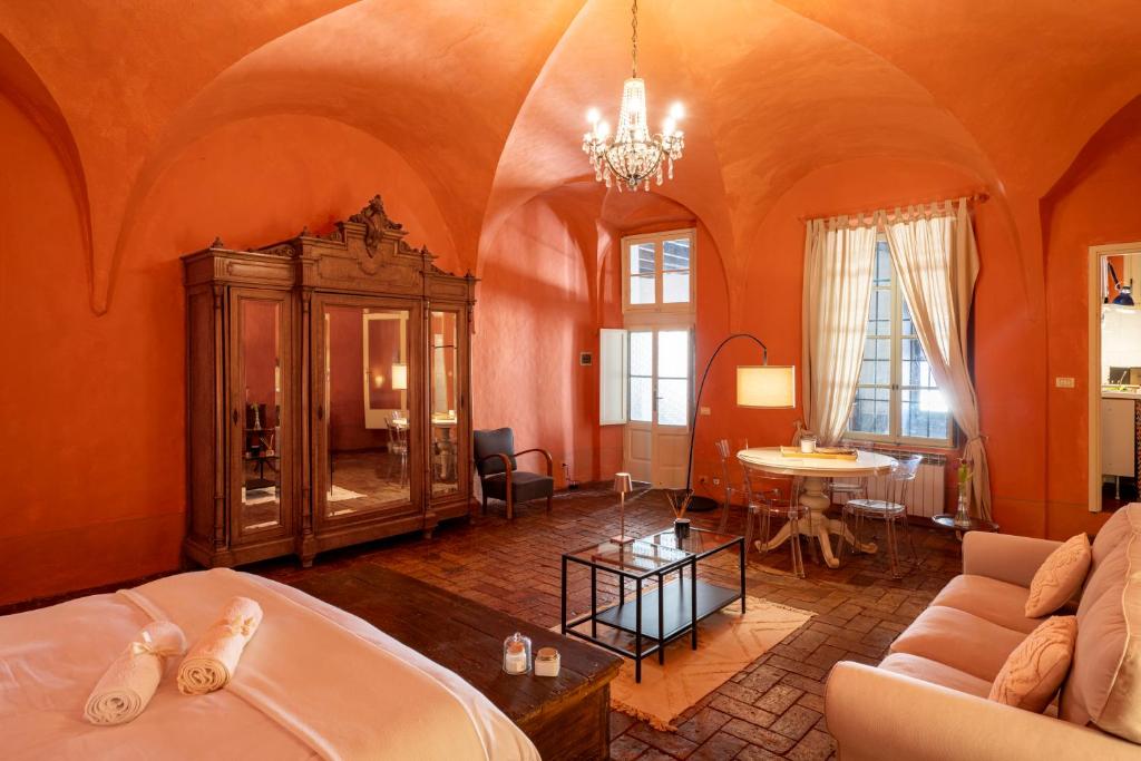 un salon avec des murs orange et un canapé et une table dans l'établissement La Corona Home - Lago d'Iseo, à Sale Marasino