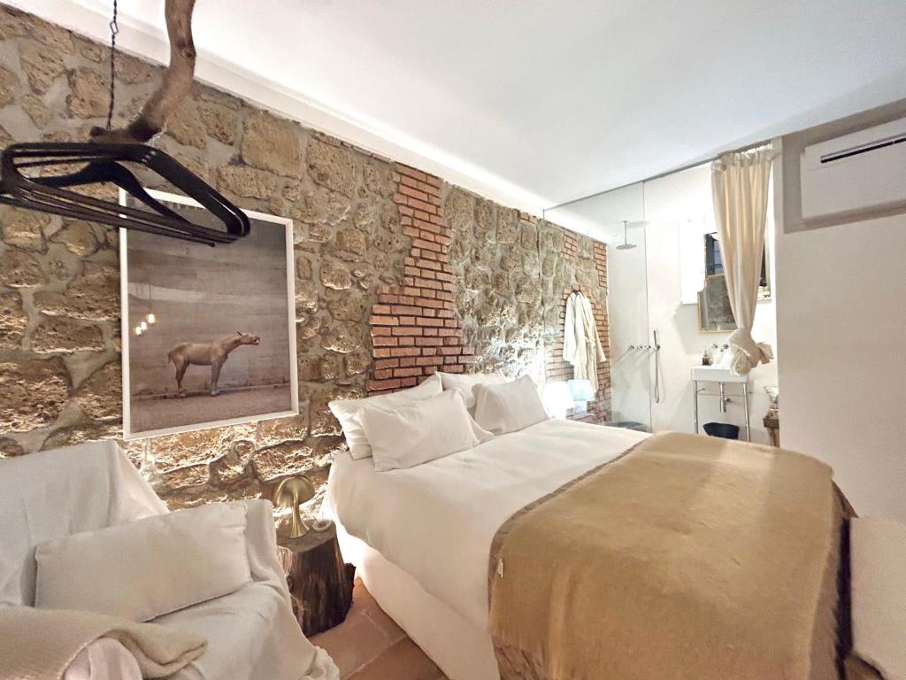 een slaapkamer met een groot bed en een stenen muur bij Super Galleria in Tuscania