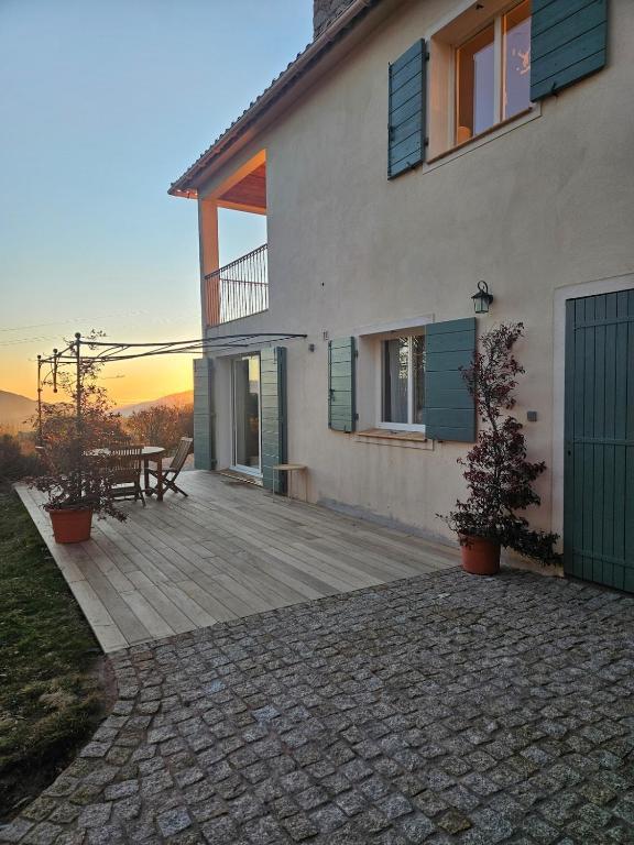 une maison avec une terrasse en bois avec une table et un banc dans l'établissement Quenza-Alta Rocca, à Quenza