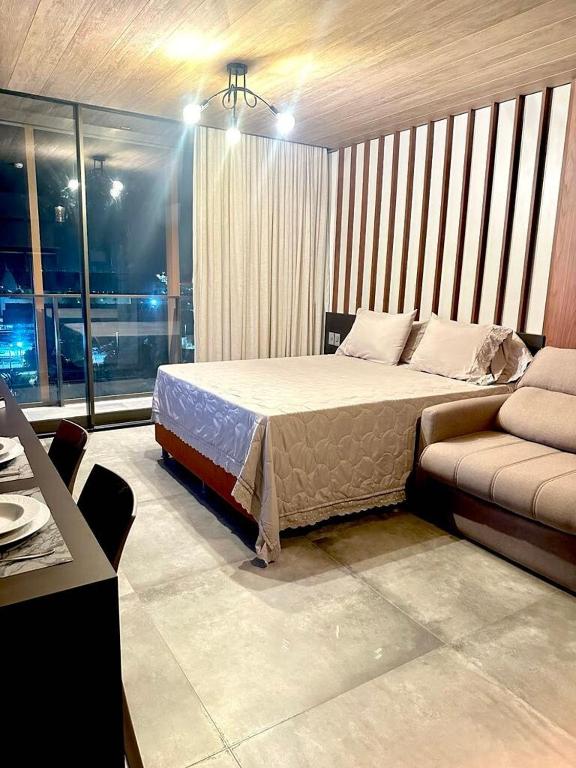 a bedroom with a bed and a couch at Apartamento Beira Mar NEW TIME 1014 in Maceió