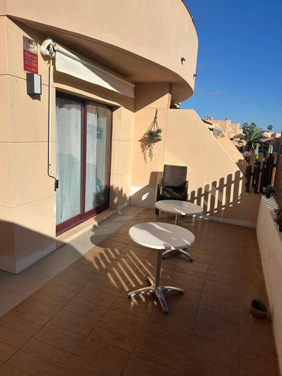 a balcony with a table and a chair on a building at Fuertevida in Caleta De Fuste