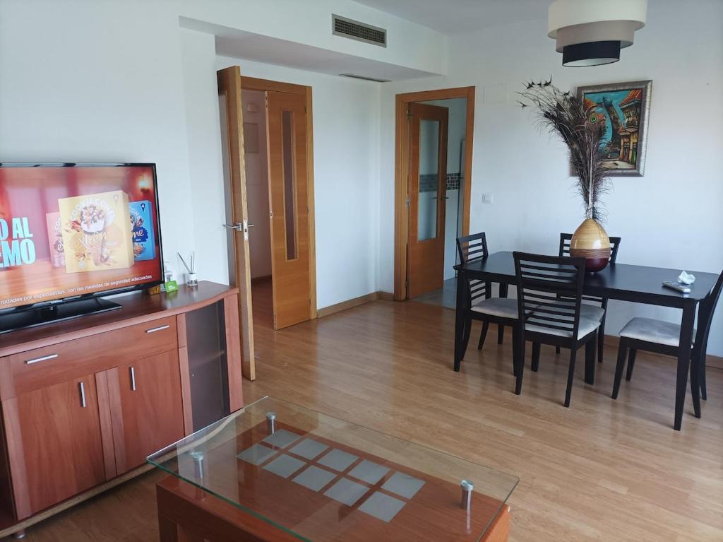 Precioso apartamento a minutos del metro في بيتيرا: غرفة معيشة مع طاولة طعام وتلفزيون