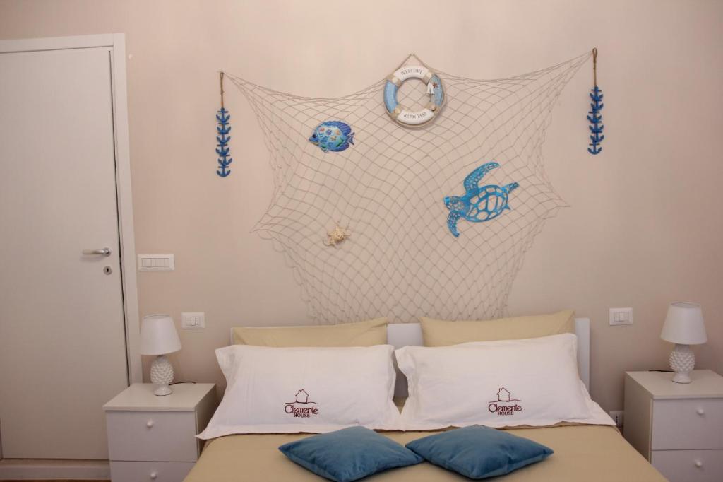 una camera da letto con un letto con un orologio a parete di Clemente House Catania Centro MERAVIGLIOSA camera matrimoniale a Catania