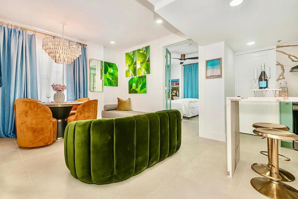 a living room with a green couch and a table at 2-Min to Beach, Upscale Enclave in Miami Beach
