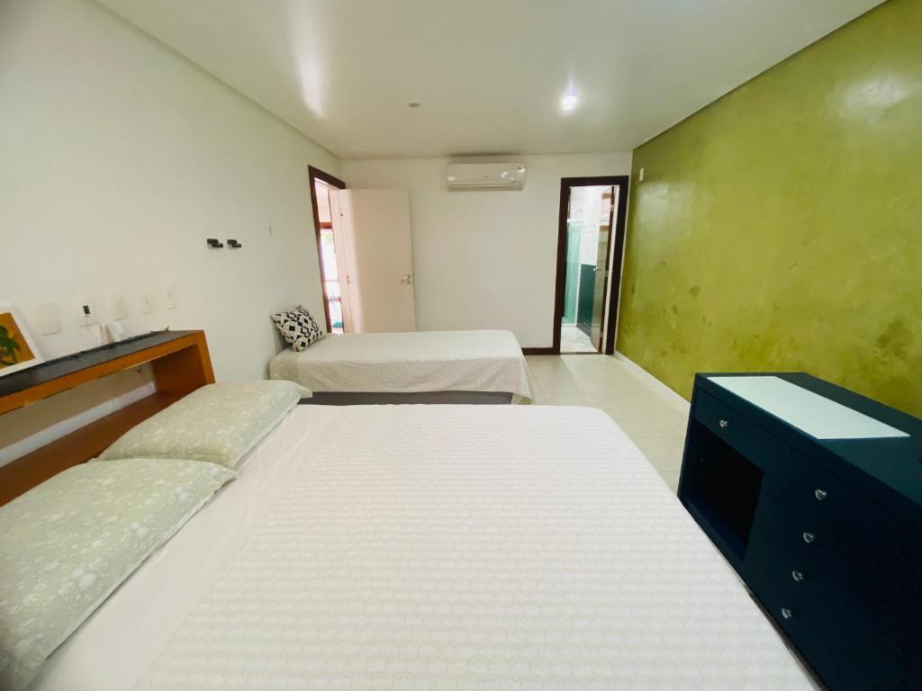 a large room with two beds and a desk at casa bela in Lauro de Freitas