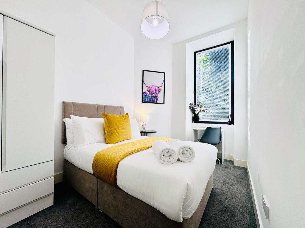 a bedroom with a bed with two towels on it at Luxury City Centre Apartment in Edinburgh