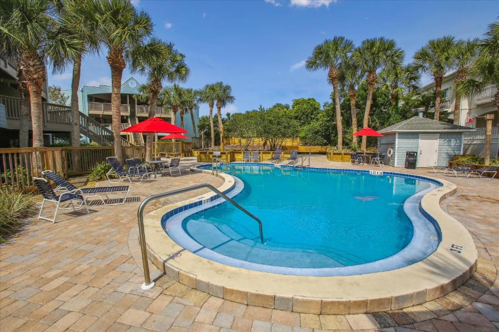 a large swimming pool with chairs and umbrellas at Tranquil Coastal Retreat in St Augustine in Saint Augustine