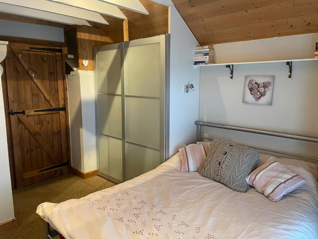 a bedroom with a bed with two pillows on it at Coaltown Cottage Cosy 4 bed cottage with log burner, close to Gower beaches in Dunvant