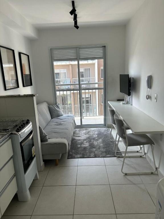 Hotel Studio com varanda, próximo Vibra Sao Paulo e Tokio Marine, a living room with a couch and a table and a desk at Studio com varanda, próximo Vibra Sao Paulo e Tokio Marine in São Paulo