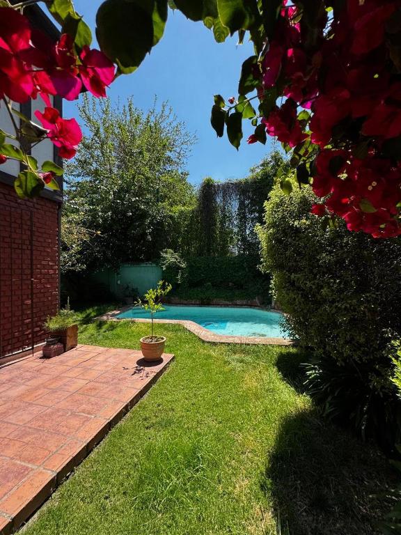 a swimming pool in a yard with a plant at Hermosa casa en Barrio Pocuro con estacionamiento gratuito in Santiago