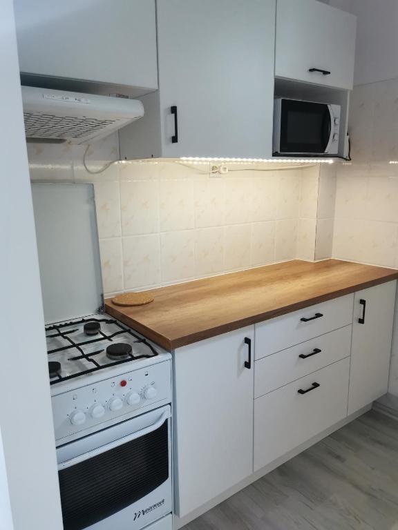 a kitchen with white cabinets and a stove top oven at Noclegi Bełchatów in Bełchatów