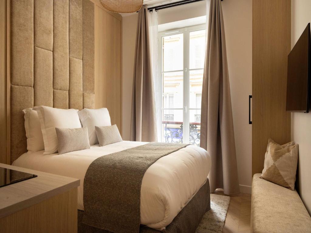 une chambre avec un grand lit et une fenêtre dans l'établissement Charming Cosy Studio - 2P - Gare Saint Lazare, à Paris