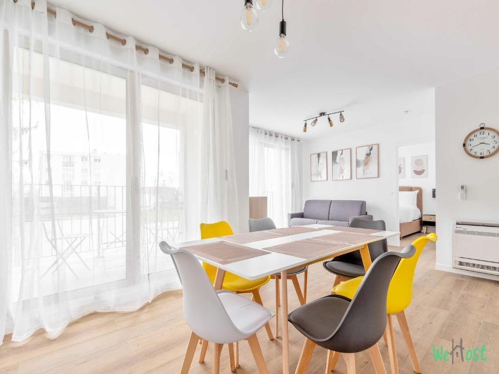 Un comedor con mesa y sillas en Résidence Saint-Amand - Proche Paris et Disneyland, en Champigny-sur-Marne