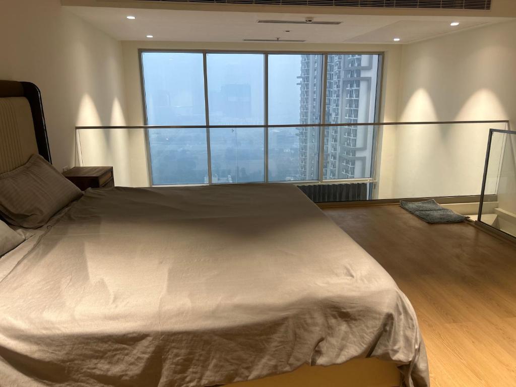 a bedroom with a large bed with a large window at Atithi Dream Studios in Gurgaon