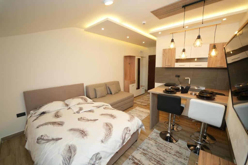 Un dormitorio con una cama y un escritorio y una cocina. en Residence Hill - Planinski Kutak, en Kopaonik