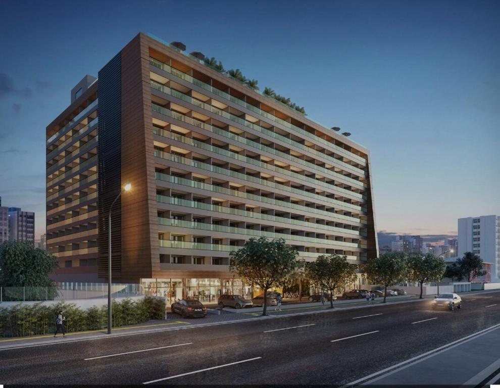 a large building on a city street with a road at Apartamento charmoso com Rooftop in Salvador