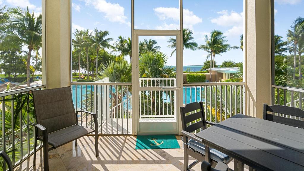 a balcony with a table and chairs and a pool at 405 Mariners Club in Key Largo