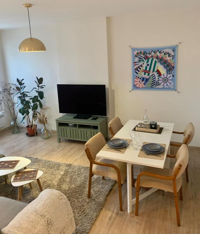 un salon avec une table et une télévision dans l'établissement Spacious and central apartment, à Reims