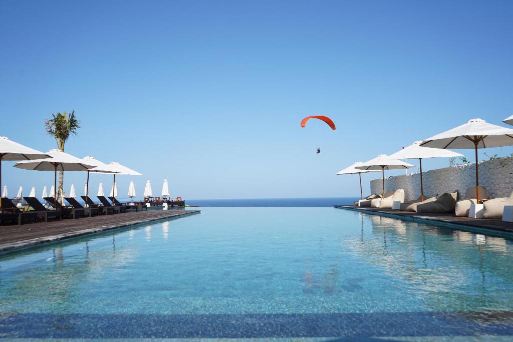 una piscina con sedie e ombrelloni di Glamp Nusa a Nusa Dua
