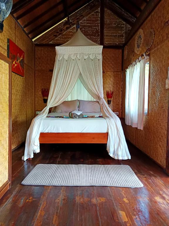 Postel nebo postele na pokoji v ubytování Kampung Meno Bungalows