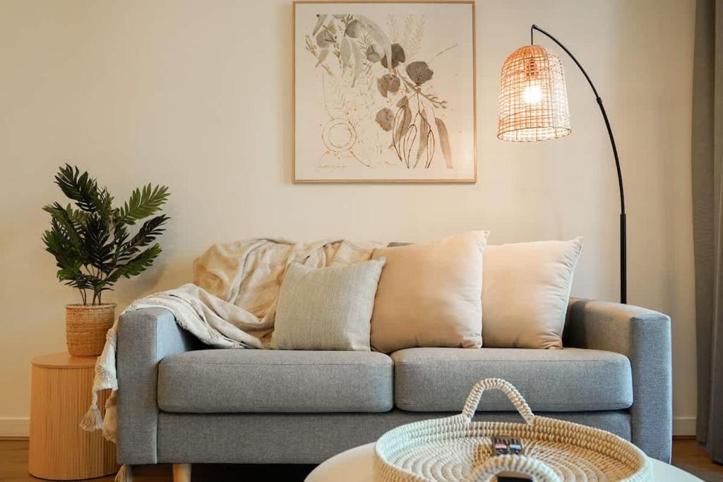 a living room with a blue couch and a lamp at Neo200 - Sophisticated 2bed CBD Apt with parking in Melbourne