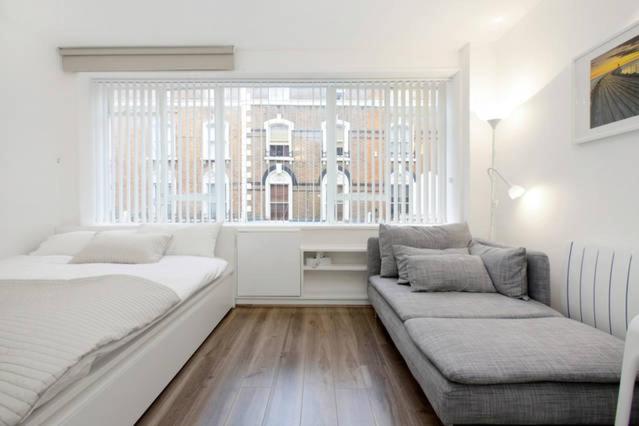 a white room with a couch and a window at Apartments Craven Terrace in London