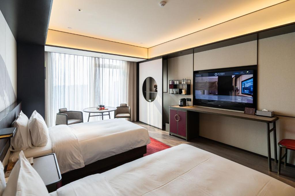 Voodi või voodid majutusasutuse JOYA Hangzhou Qianjiang New Town toas