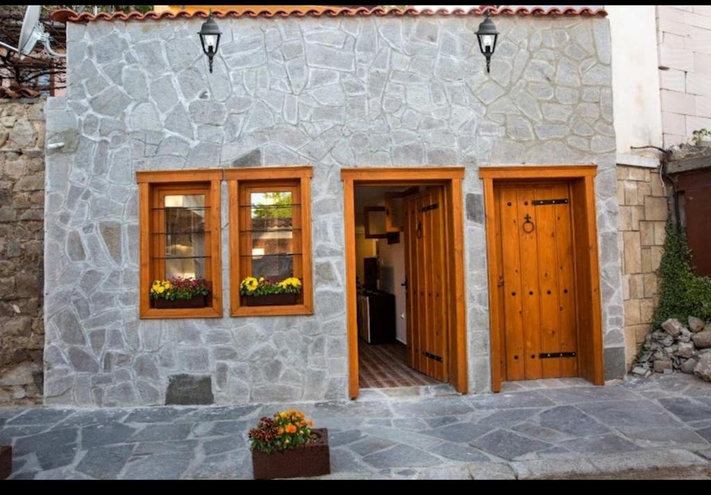 una casa de piedra con puertas y ventanas de madera en Marchevi in the Old Town, en Plovdiv
