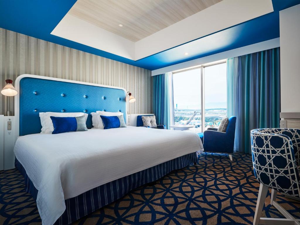 a bedroom with a large bed and a blue wall at Hotel Universal Port in Osaka