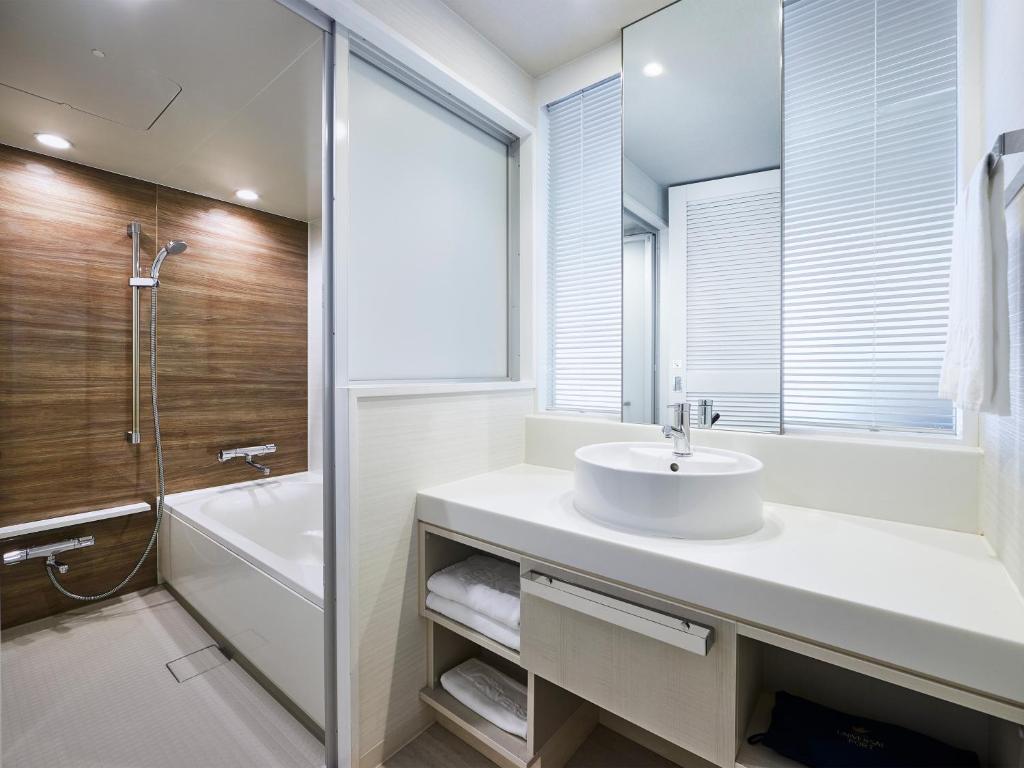 a bathroom with a sink and a tub and a shower at Hotel Universal Port in Osaka