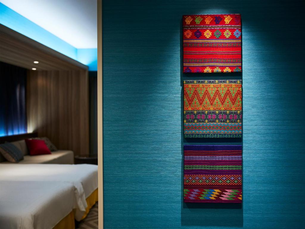 a room with a bed and a colorful rug on the wall at Hotel Universal Port in Osaka