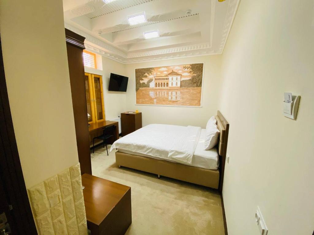 ein Schlafzimmer mit einem Bett und einem Schreibtisch darin in der Unterkunft Orbita Villa boutique in Buxoro