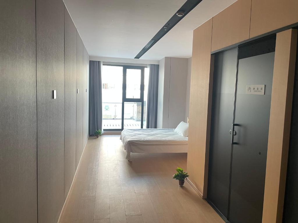 a bedroom with a bed and a door with a window at Dengba Inn-Shanghai New World Plaza Branch in Shanghai