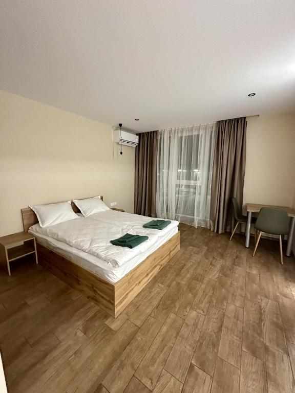 a bedroom with a large bed and wooden floors at Music Flats in Sofia