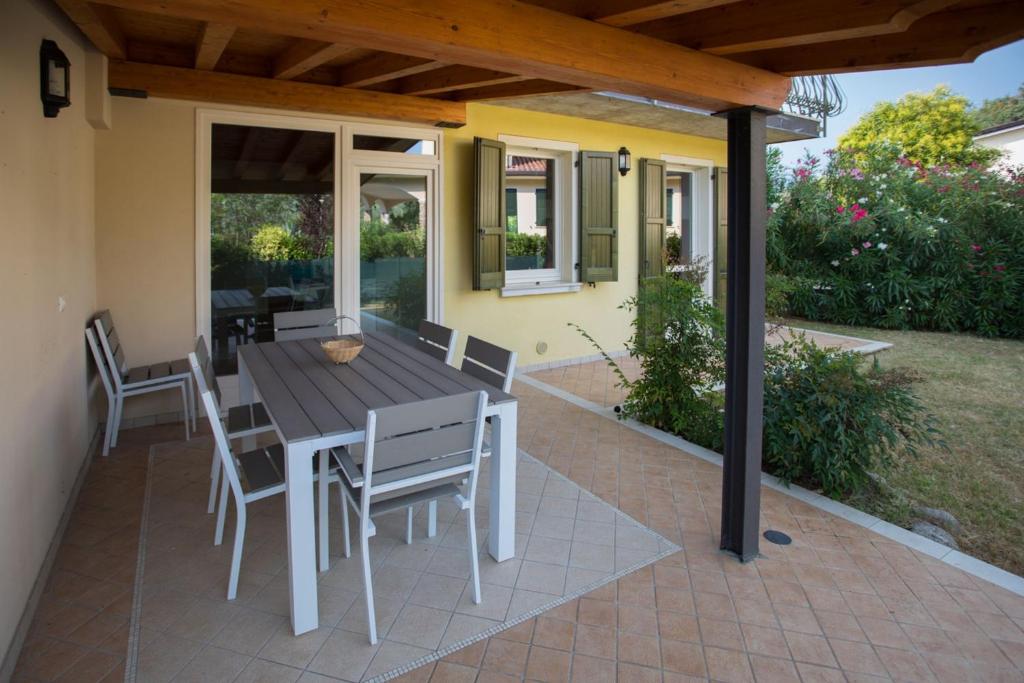 a patio with a wooden table and chairs on a house at Wonderful villa on the Garda Lake with private garden in Salò