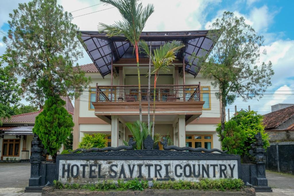 a hotel synergy community sign in front of a building at RedDoorz at Savitri Hotel in Yogyakarta