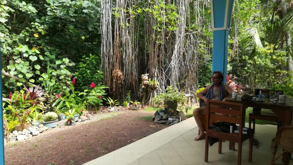 ベルワラにあるLagoon Villa Beruwalaの庭前の机に座る男