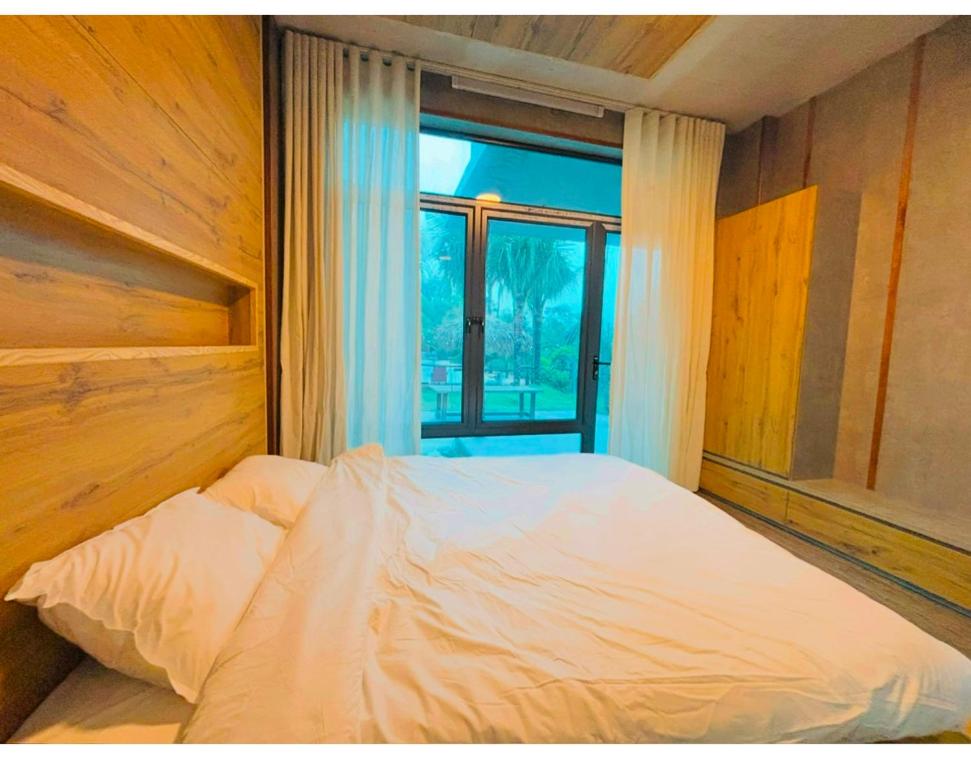 a bed in a room with a window at BIRD HOUSE resort in Hữu Biêt